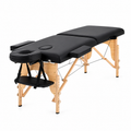  Black portable folding massage bed with wooden frame, face cradle and adjustable armrests.